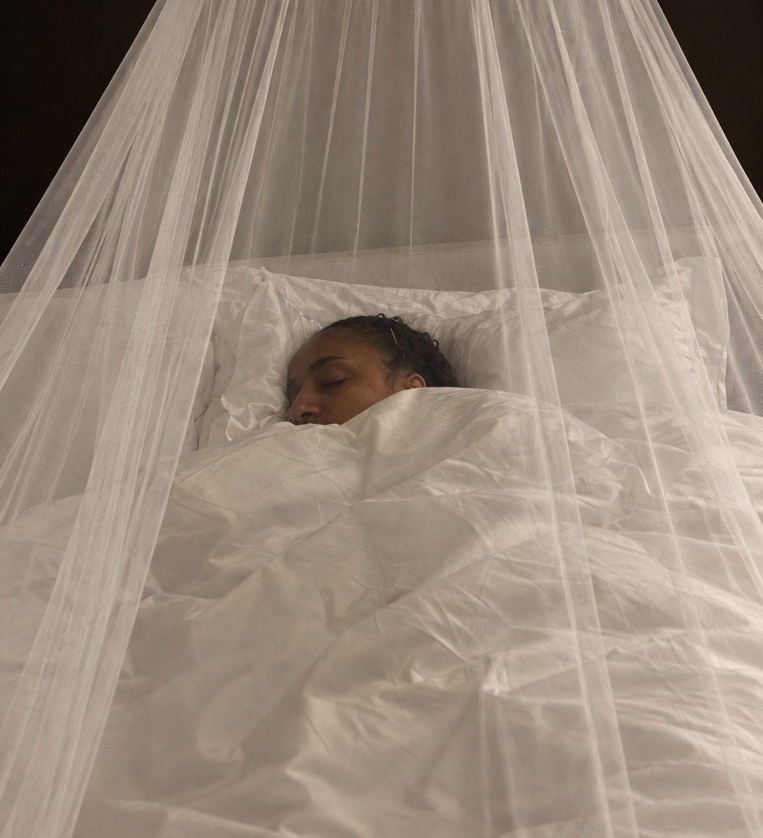 South African customer sleeping under a white NestHaven net