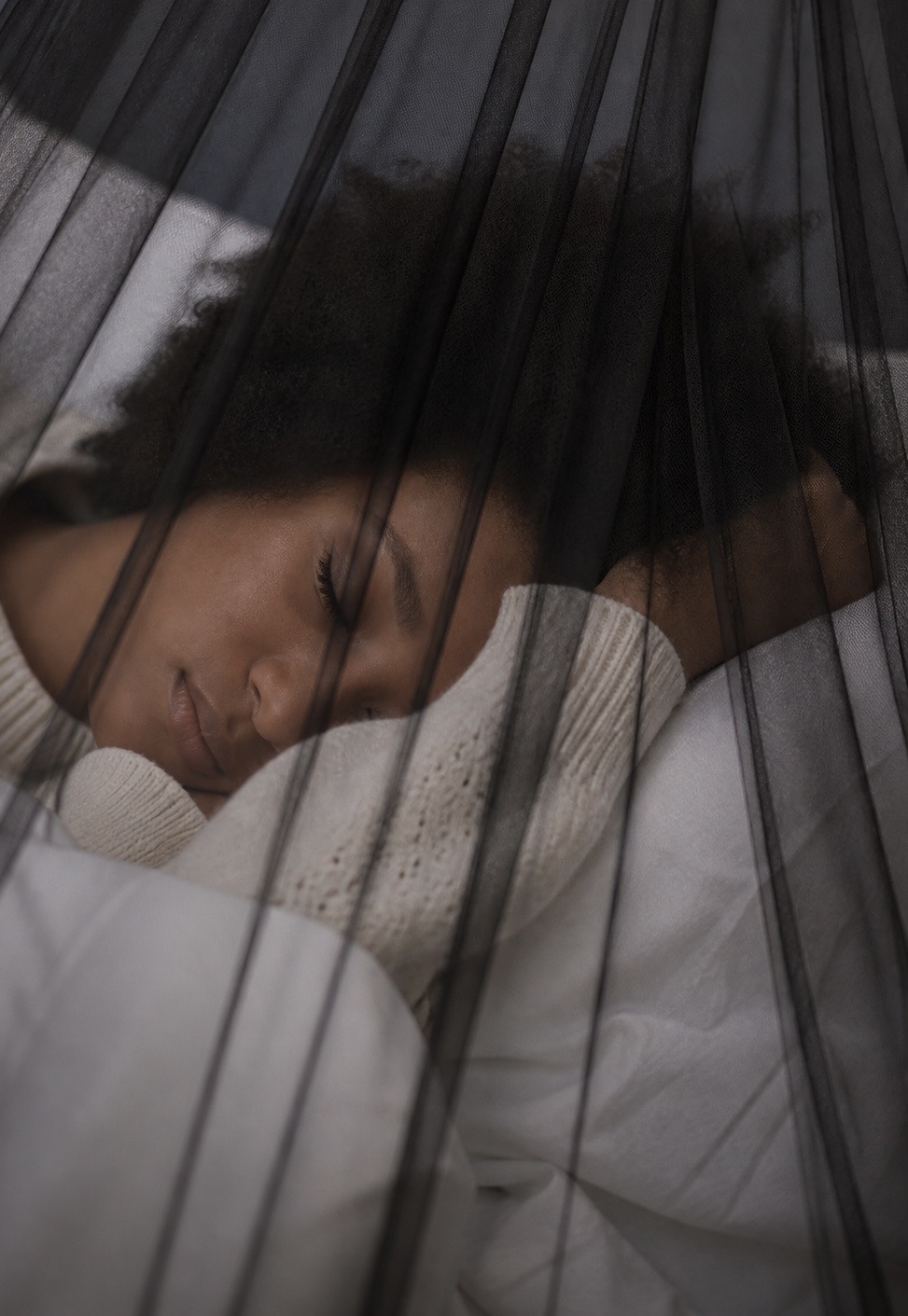 Person sleeping peacefully under a NestHaven mosquito net